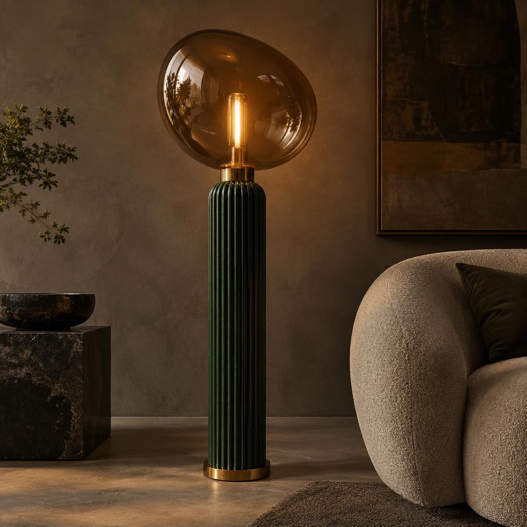 Fluted emerald ceramic floor lamp with brass collars and a glowing amber glass globe
