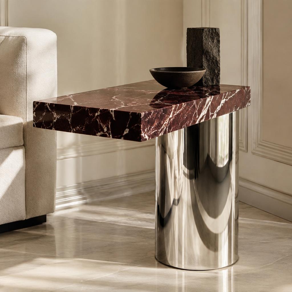 Oxblood marble slab cantilevered over a mirror-polished steel drum
